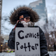 A protester holds a sign reading “Convict Potter, End Qualified Immunity” outside the Hennepin County Government Center as the trial of former Brooklyn Center police officer Kim Potter begins on December 8, 2021, in Minneapolis, Minnesota. - Wright, 20, was shot and killed during a traffic stop in the Minneapolis suburb of Brooklyn Center on April 11 by Potter, who reportedly confused her handgun for her taser.